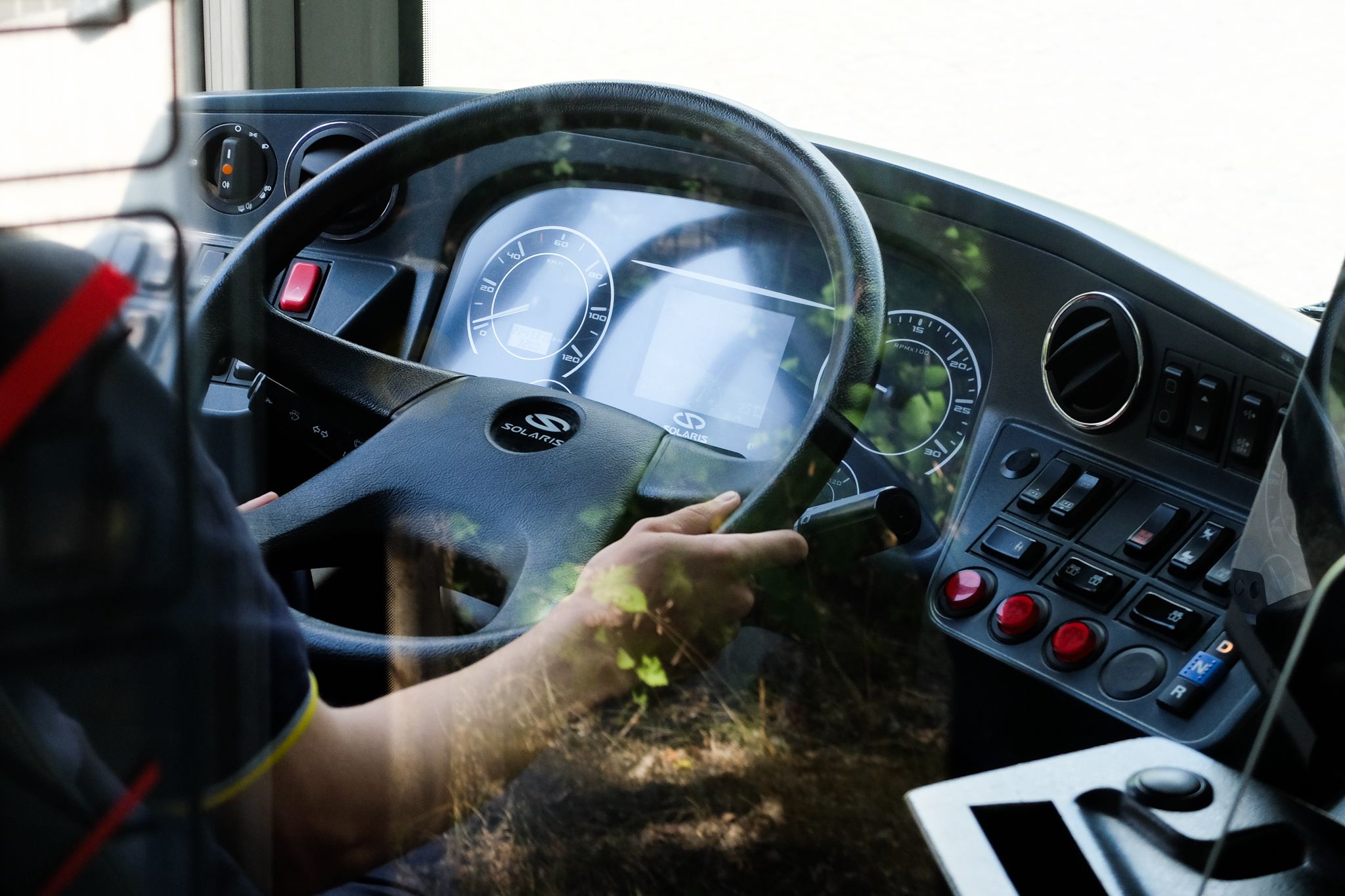 a man sitting in a bus driving down the street